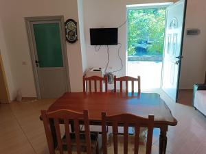 a dining room with a table and chairs and a television at FETAHU HOSTEL in Poliçan