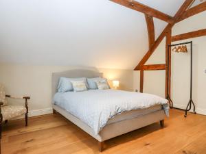 a bedroom with a bed and a chair at The Acorn Barn in Exeter