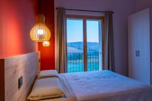 a bedroom with a bed and a large window at Agriturismo Cà Vida in Ziano Piacentino