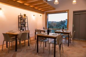 ein Esszimmer mit Tischen und Stühlen und einem großen Fenster in der Unterkunft Agriturismo Cà Vida in Ziano Piacentino