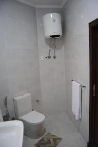 a white bathroom with a toilet and a sink at Villa 3 Studios in 6th Of October