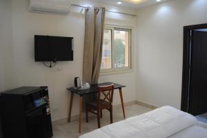 a room with a desk and a tv and a bed at Villa 3 Studios in 6th Of October