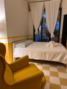 a bedroom with a bed and a chair and a window at Le Case di LuVi in Nola