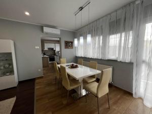 a dining room with a white table and chairs at Modern two bedroom flat with balcony in Lenti