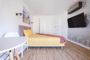 1 dormitorio con 1 cama y TV de pantalla plana en Golden Apartment in Palm Park, en Torrevieja