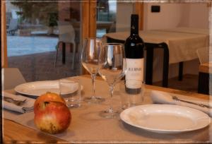 a bottle of wine and two glasses on a table at Agriturismo Cà Vida in Ziano Piacentino
