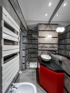 bagno con lavabo e mobile con lavabo rosso. di Bubi House Moscova a Milano