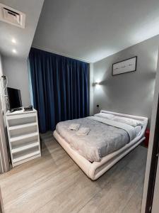 una camera con un letto e un comò con una televisione di Bubi House Moscova a Milano