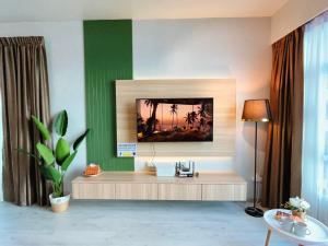 a living room with a tv on a green wall at Mango House6-High floor I Biggest unit I SeaView I Waterfilte I Wifi-JQ in Kota Kinabalu