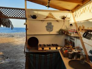 a kitchen with a stove top oven next to the beach at COSMOS eco Lodge and Spiritual community in Dahab