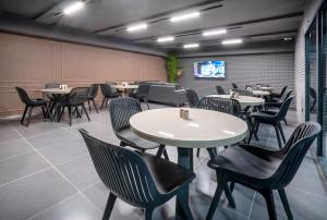 a dining room with tables and chairs and a tv at Hotel Best Tbilisi in Tbilisi City