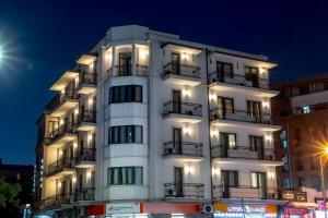 un edificio blanco con balcones y luces. en Hotel Best Tbilisi en Tiflis