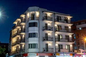 a white building with balconies and lights on it at Hotel Best Tbilisi in Tbilisi City