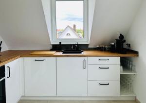 eine Küche mit weißen Schränken und einem Fenster in der Unterkunft Bergblick-Apartment IStayUnixI Seenähe-Workspace-Netflix I KEINE Monteure in Friedrichshafen