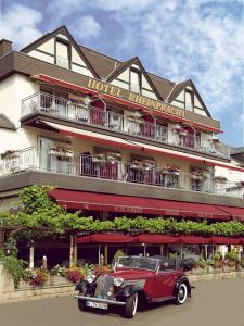 un viejo coche rojo estacionado frente a un hotel en Hotel Garni Rheinpracht en Kamp-Bornhofen