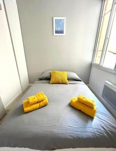 a bed with two yellow pillows in a room at Congrès Résidence in Nice