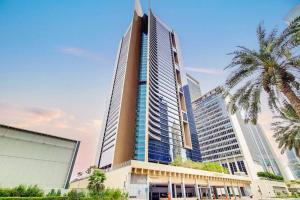 Sky Gardens - Luxury Studio in Central DIFC في دبي: مبنى طويل اشجار النخيل امامه