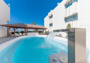 a swimming pool with a water fountain in front of a building at Port Azafata Valencia in Manises