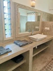 a bathroom with a sink and a mirror at 765 Breezebay suites in Watamu +10 photos