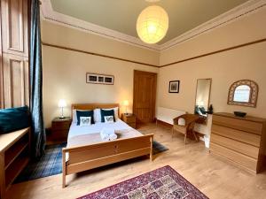 a bedroom with a large bed and a table at Beautiful Spacious Ground Floor Newington flat in Edinburgh