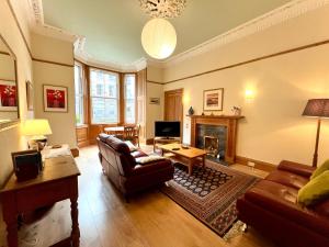 uma sala de estar com um sofá e uma lareira em Beautiful Spacious Ground Floor Newington flat em Edinburgo