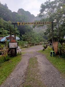 a dirt road with a sign that readsarma all earth at Tapian Ratu Camp in Bukittinggi
