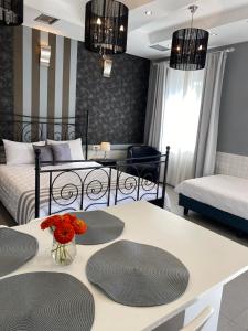 a bedroom with two beds and a table with flowers on it at Apollonio Upper View Suites in Korinthos