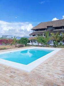 a swimming pool in front of a house at 765 Breezebay suites in Watamu