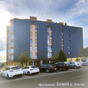 a large building with cars parked in front of it at CORAZÓN DE ASTURIAS in Piedras Blancas