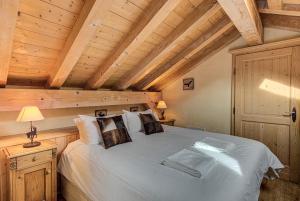 シャモニー・モンブランにあるAPARTMENT LONGVIEW - Alpes Travel - Central Chamonix - Sleeps 8の木製の天井の客室で、ベッドルーム1室(大型ベッド1台付)