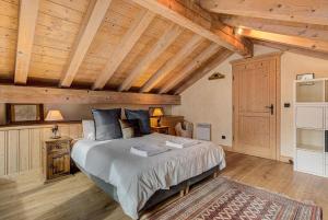 シャモニー・モンブランにあるAPARTMENT LONGVIEW - Alpes Travel - Central Chamonix - Sleeps 8の木製の天井が特徴のベッドルーム1室(ベッド1台付)