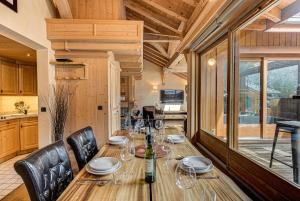 シャモニー・モンブランにあるAPARTMENT LONGVIEW - Alpes Travel - Central Chamonix - Sleeps 8のダイニングルーム(木製テーブル、ワイングラス付)
