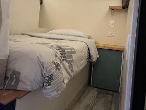 małe łóżko w małym pokoju ze spódnicą w obiekcie The Cranky Croc Hostel w mieście Bogota