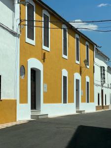 a yellow and white building with white doors and windows at CASA RURAL SOLARIEGA DE LABRANZA in Doña Rama