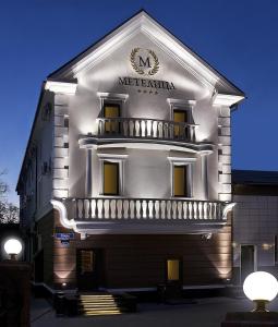 un gran edificio blanco con un cartel. en Metelitsa Hotel en Krasnoyarsk