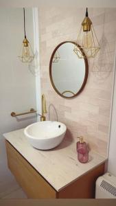 W łazience znajduje się biała umywalka i lustro. w obiekcie Villa Simpatía w mieście Merza
