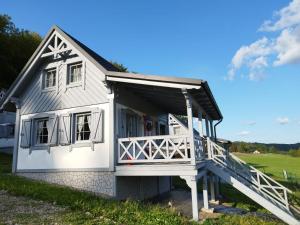 Casa blanca con porche y balcón en Domki pod Kapeluszem nad jeziorem Patulskim,Kaszuby z opcją balii, en Pierszczewo