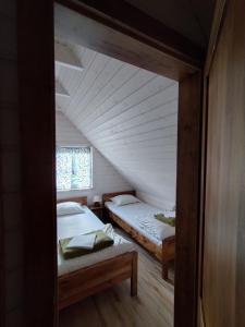 Habitación con 2 camas en un ático en Domki pod Kapeluszem nad jeziorem Patulskim,Kaszuby z opcją balii, en Pierszczewo