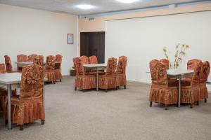 a conference room with tables and chairs and a screen at Park Hotel Ivailo in Veliko Tŭrnovo
