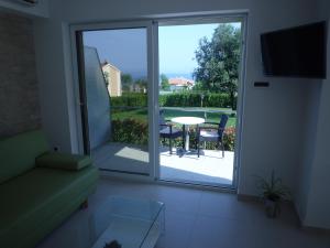 a living room with a sliding glass door leading to a patio at Villa Simfonija in Malinska