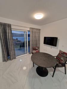 - un salon avec une table, des chaises et une télévision dans l'établissement Apartments Filipo, à Trogir
