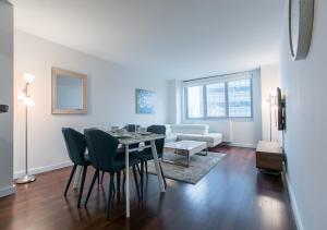 a living room with a table and chairs and a couch at Stunning 1BD 1BA At UES in New York