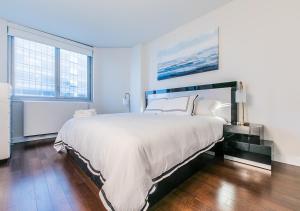 a bedroom with a large bed and two windows at Stunning 1BD 1BA At UES in New York