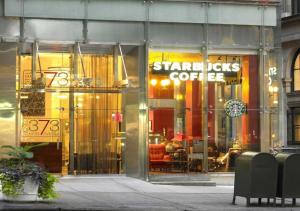 un frente de tienda con un cartel de café Starbuck en la ventana en Stunning 1BD 1BA At UES en Nueva York