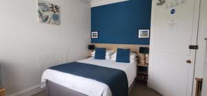 a bedroom with a bed with a blue wall at Hazeldene Guest House in Perth