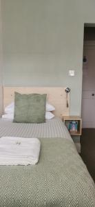 a bed with a green pillow on top of it at Hazeldene Guest House in Perth