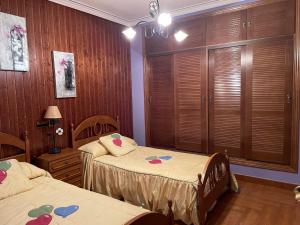 two beds in a room with wooden walls at Casa espaciosa con sala de juntas in Consuegra