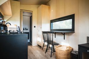 a kitchen with a table and chairs in a tiny house at White House Hideaway in Brockhampton