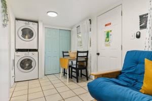 a living room with a washing machine and a blue couch at Sea Haven Motel Unit 2. in Rockaway Beach