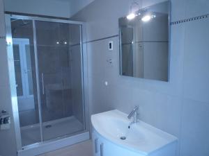 a white bathroom with a shower and a sink at Villa Simfonija in Malinska +48 photos